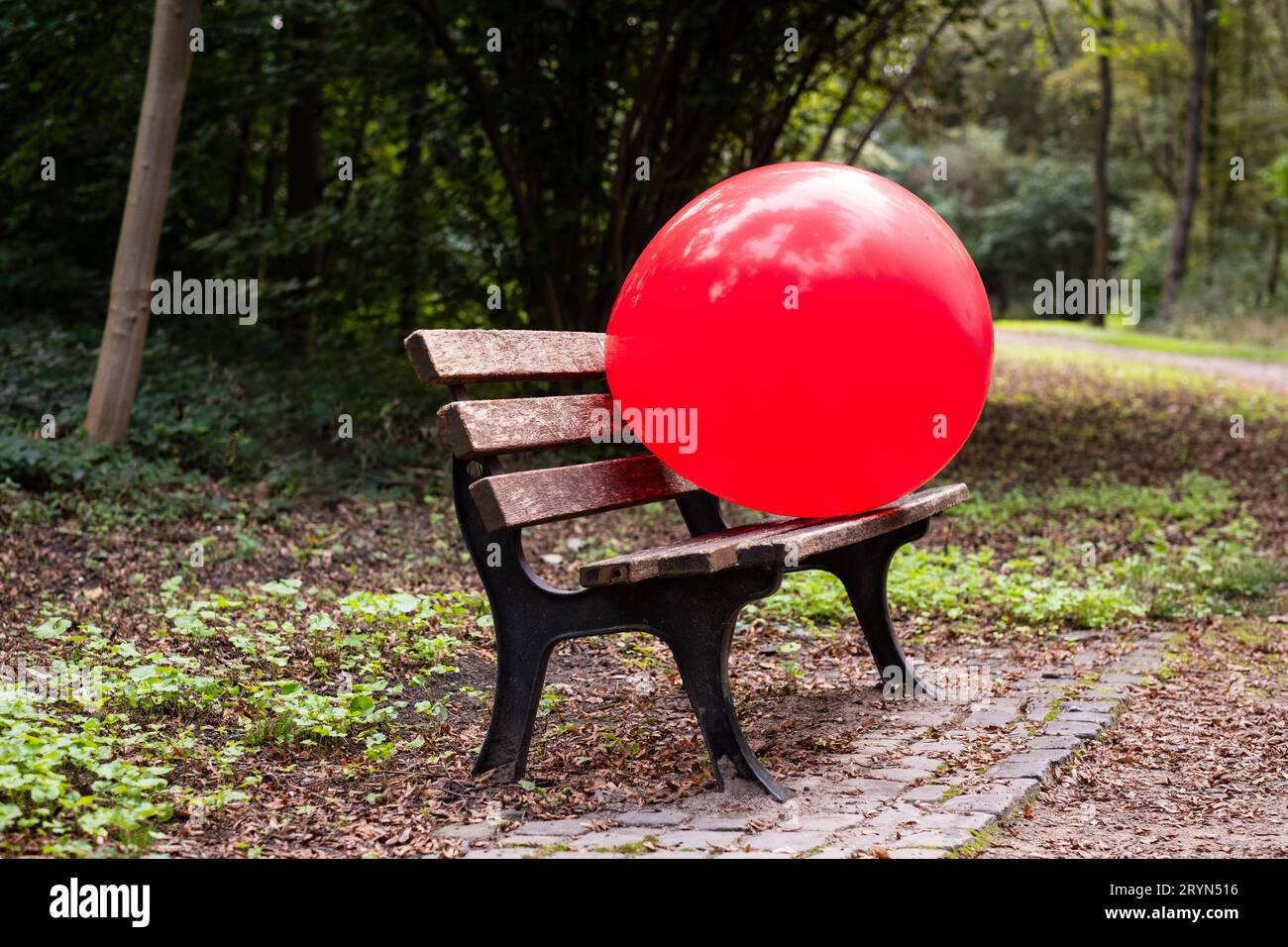 Una mongolfiera gigante rossa su una panchina in un parco a Duesseldorf, Germania Foto Stock