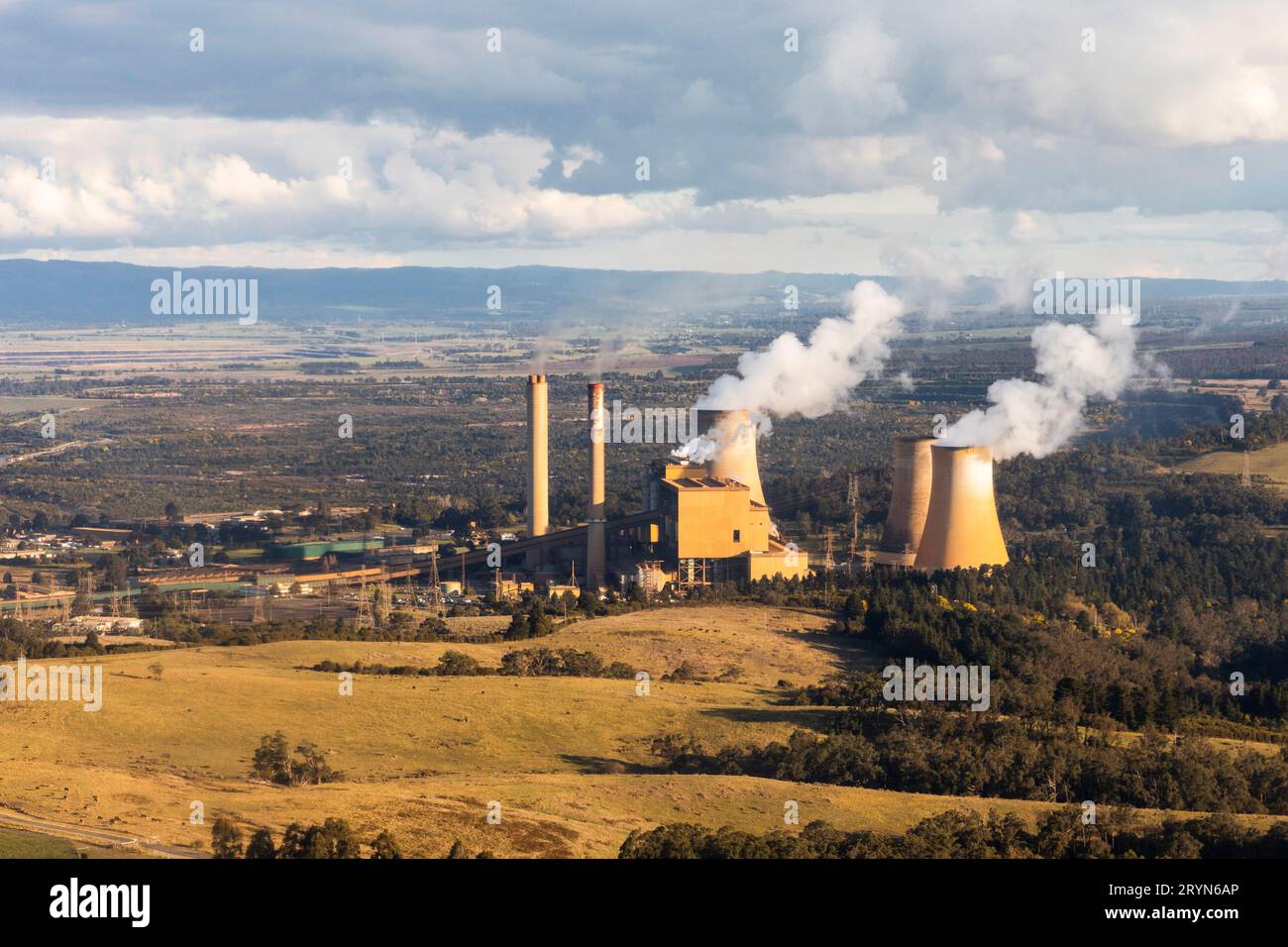 Il fumo proveniente da torreggianti fumogeni si disperde nell'atmosfera all'interno di un paesaggio verde. Foto Stock