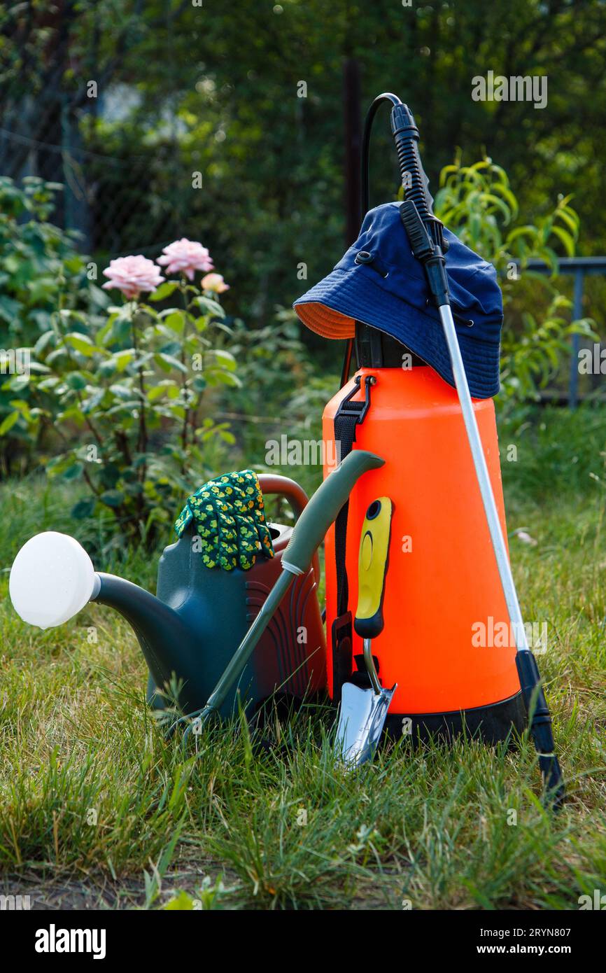 Fertilizzante giardino antiparassitari irroratrice, annaffiatoio e alcuni  attrezzi da giardino sul prato con erba verde Foto stock - Alamy