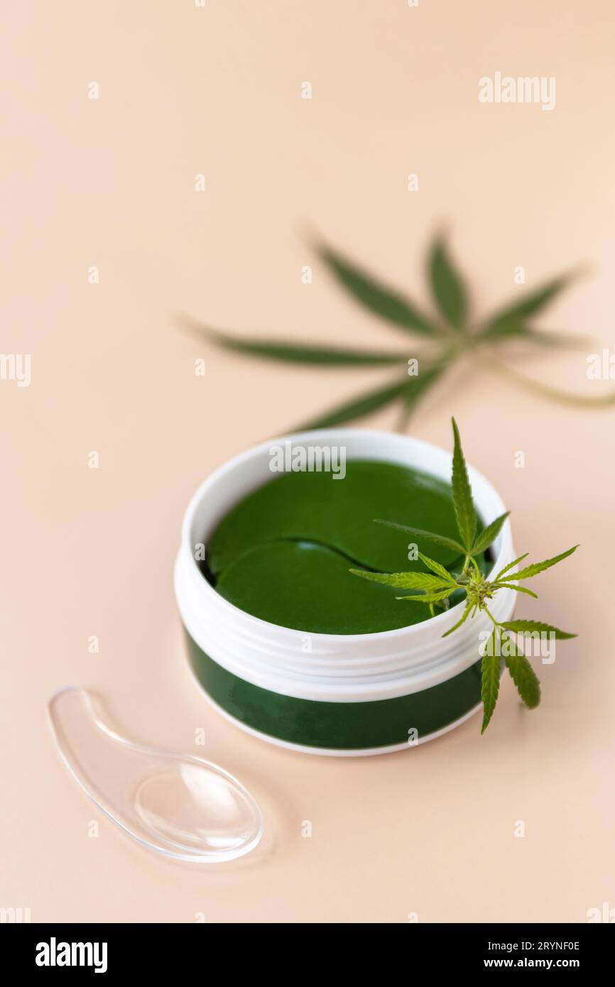 Idrogel cerotti occhi verdi in vaso. Idrogel Anti invecchiamento e sollevamento cura. Prodotto cosmetico per la cura della pelle con foglie di cannabis. Foto Stock