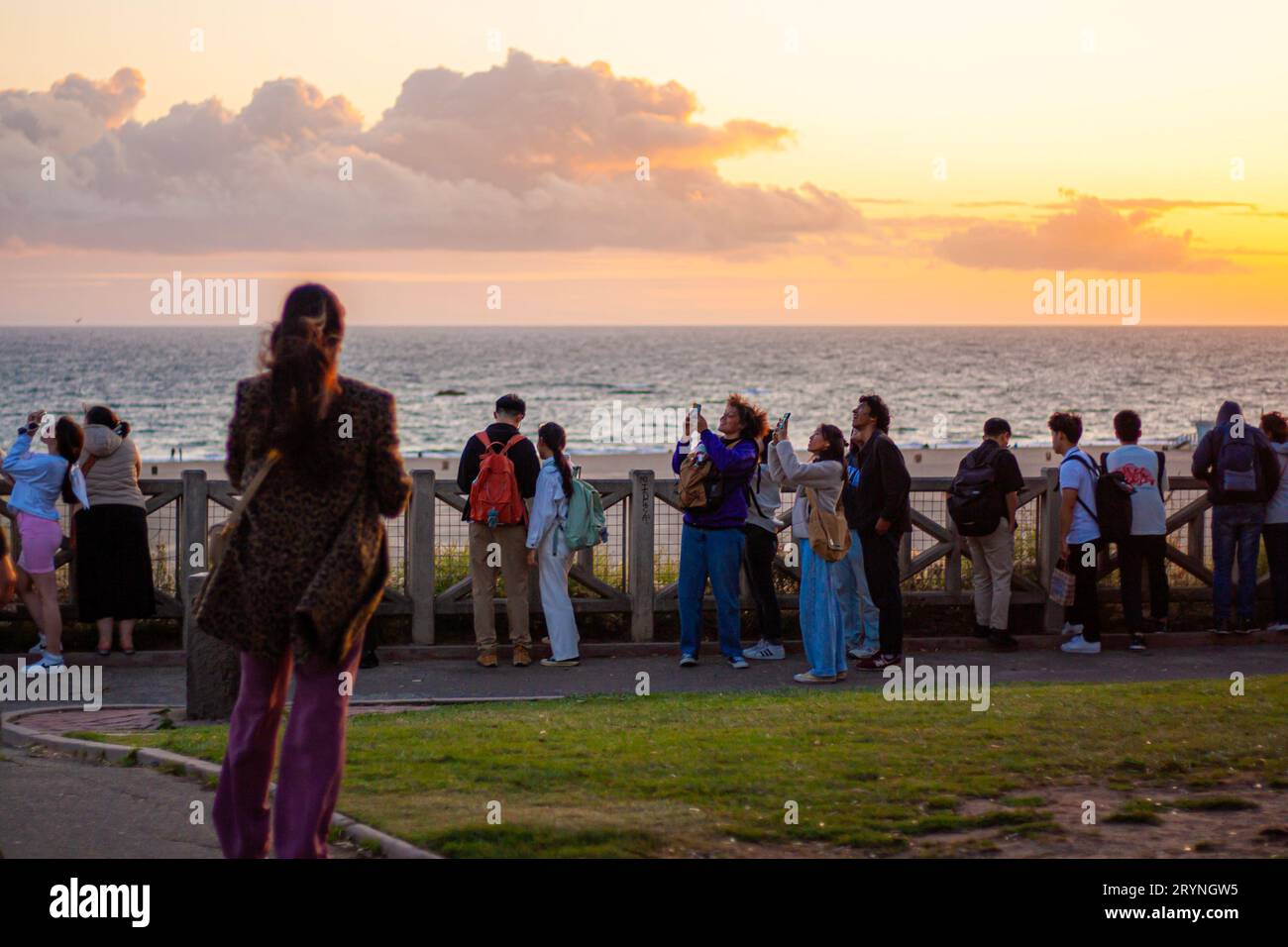 La gente guarda il cielo al tramonto Foto Stock