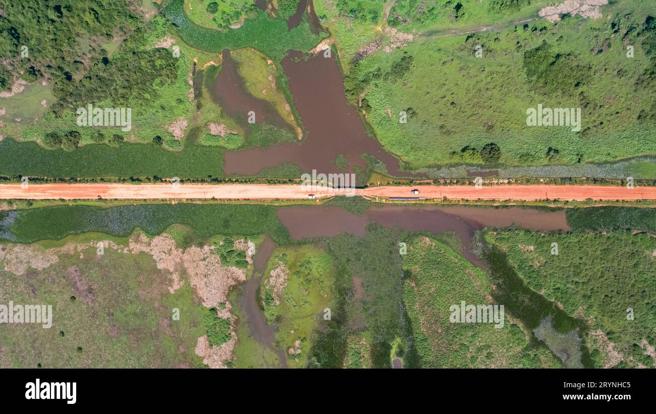 Veduta aerea della strada sterrata di Transpantaneira che attraversa il tipico paesaggio delle paludi Pantanal con lagune, fiumi, prati e foreste, Mato Grosso, Brasile Foto Stock