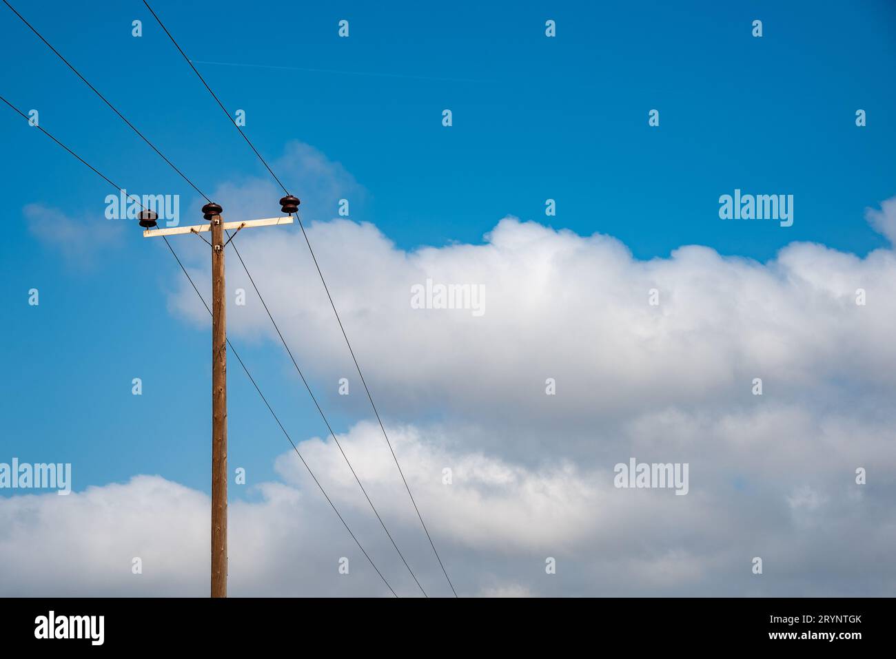 Linee di trasmissione dell'energia elettrica che trasferiscono l'energia elettrica all'esterno. Cielo nuvoloso blu. Copia spazio Foto Stock