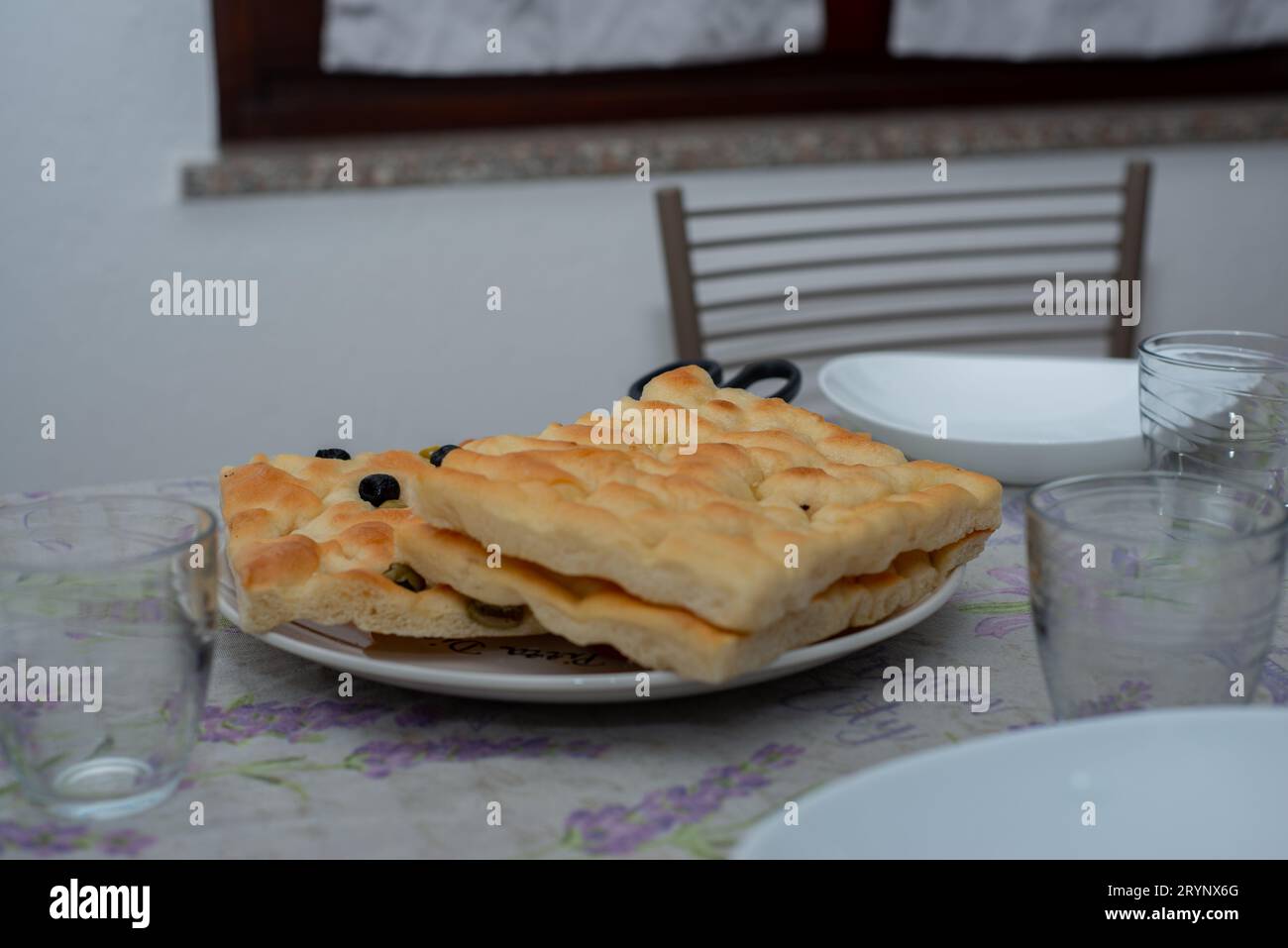 Primo piano della focaccia genovese sul tavolo posato. Piatti italiani fatti in casa Foto Stock