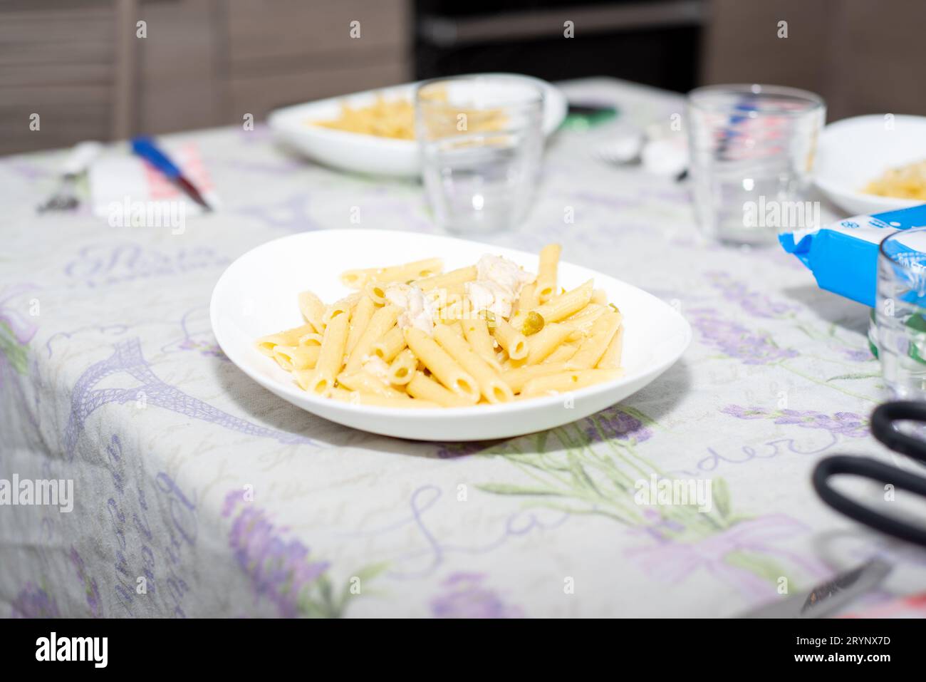 penne, pasta italiana con pollo e piselli su tavola Foto Stock