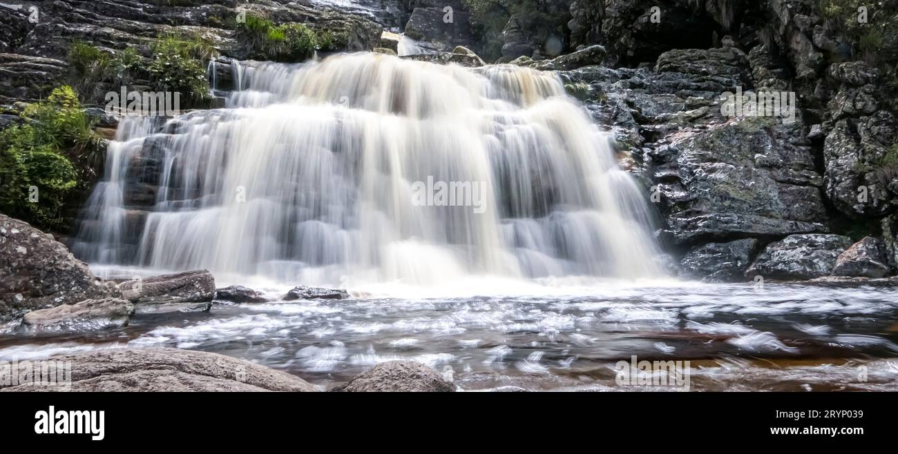 Primo piano di una cascata con il moto d'acqua e laghetto, parco naturale di Caraca, Minas Gerais, Brasile Foto Stock