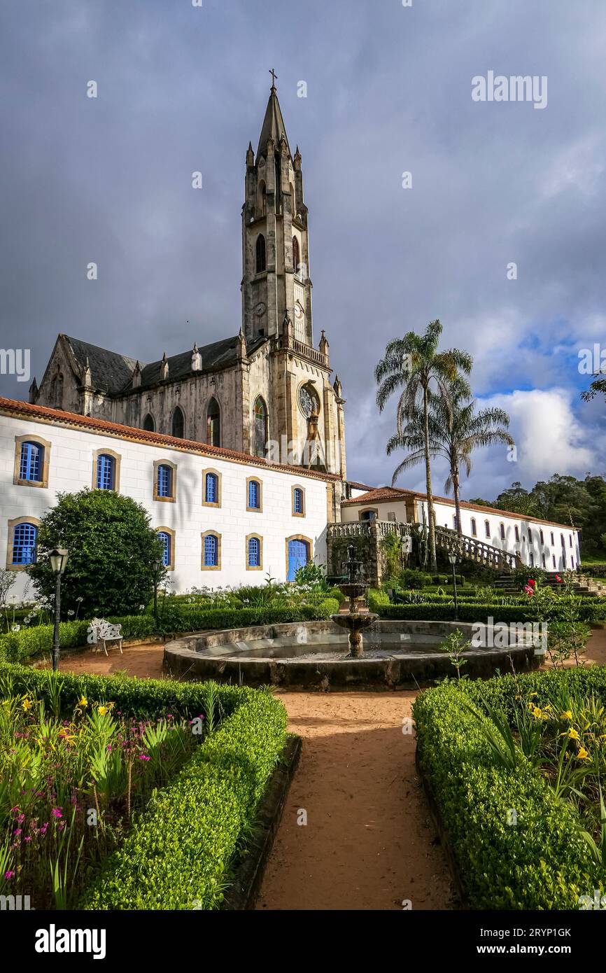 Vista della chiesa e degli edifici alla luce del sole con nuvole grigie sullo sfondo, Sanctuary Caraca, Minas Ger Foto Stock