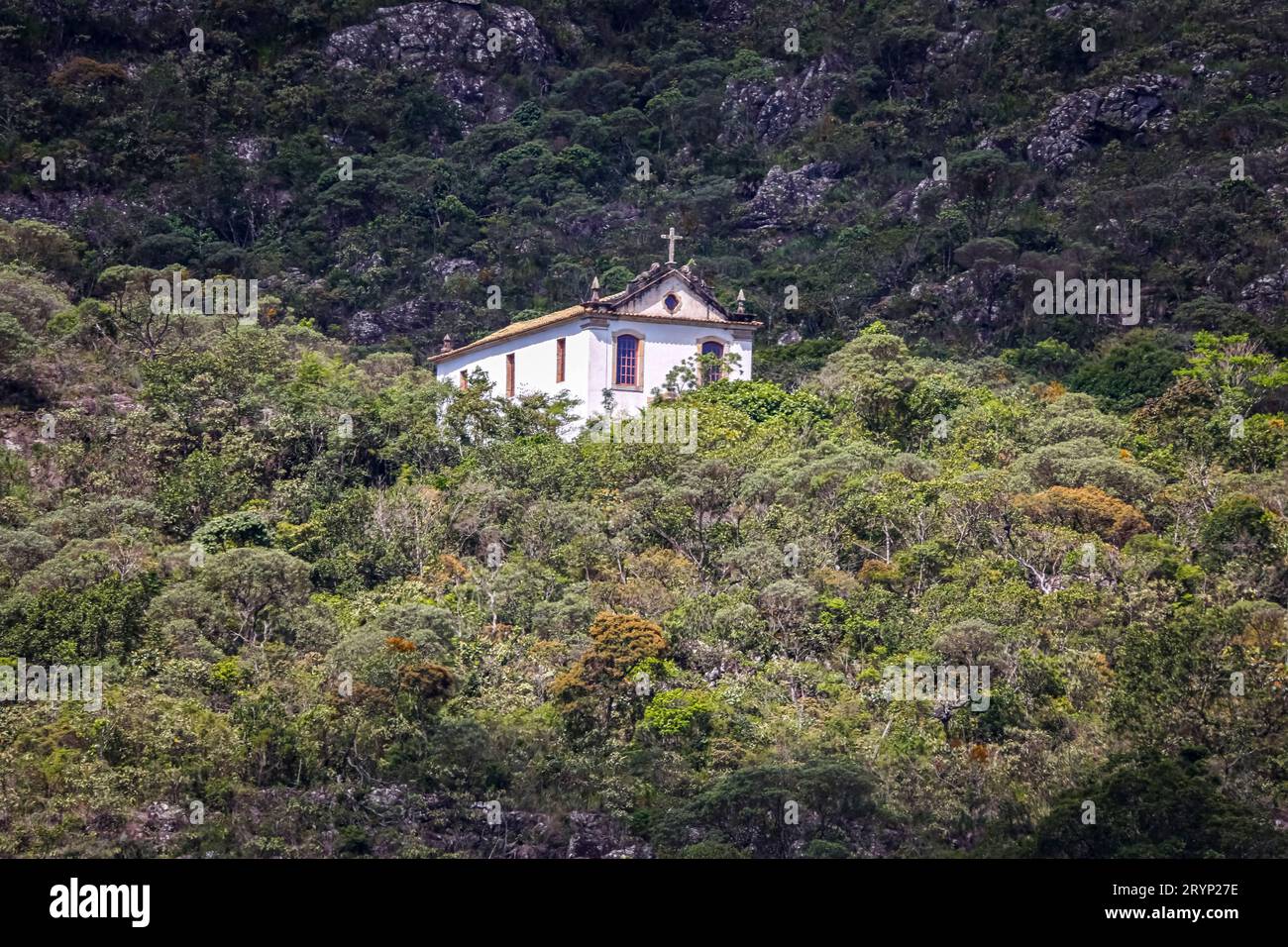 Piccola cappella storica alla luce del sole circondata dalla foresta atlantica e dalle montagne, il Parco naturale di Caraca, M. Foto Stock
