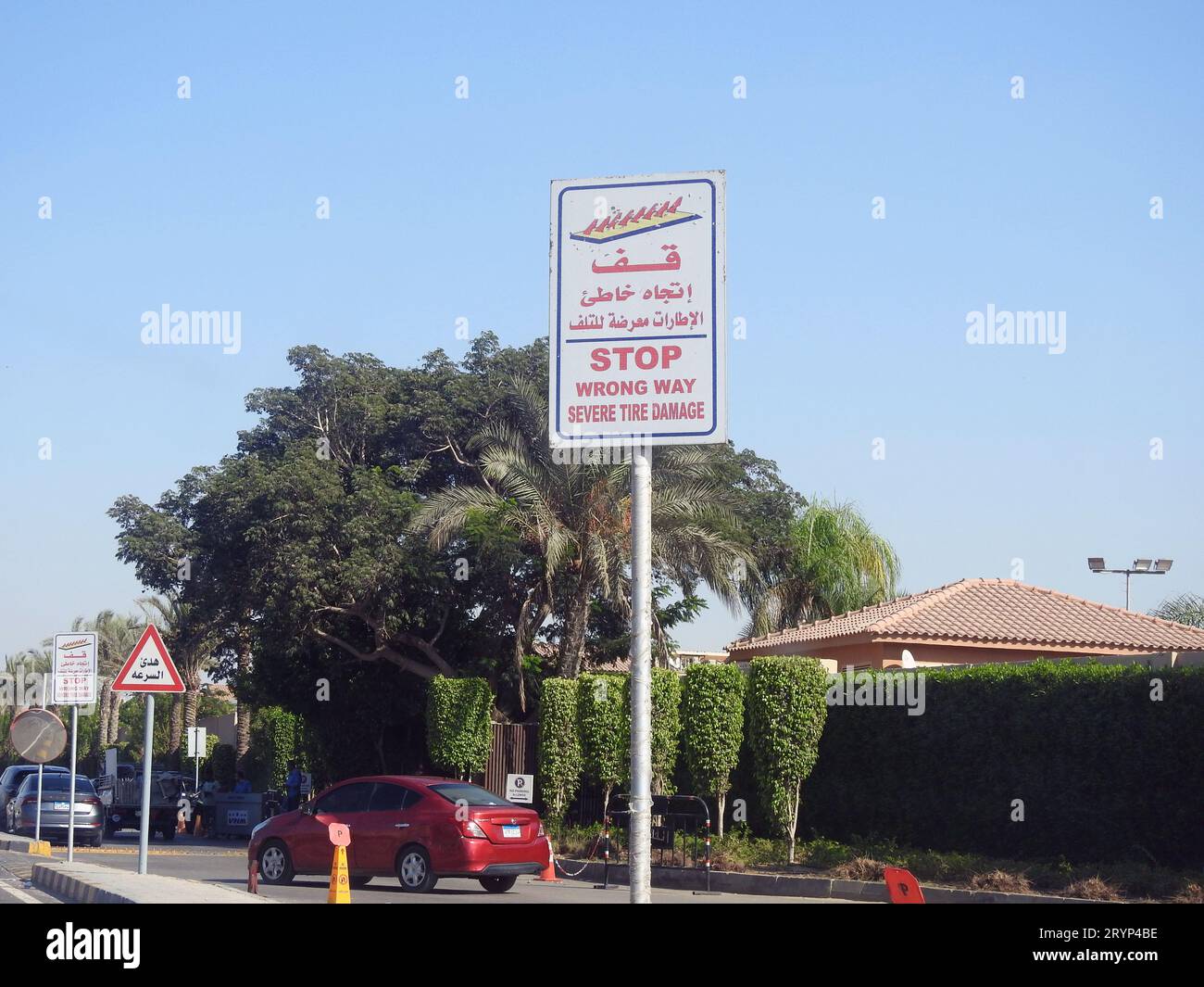 Cairo, Egitto, 17 settembre 2023: Cartello segnaletico stradale, traduzione dell'arabo (Stop, Wrong Way, severe Tire Damage), come precauzione prima di una barriera a picco Foto Stock