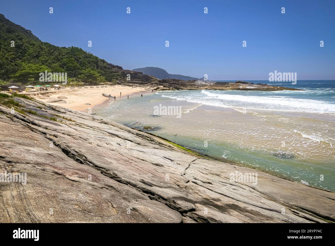 Ammira la costa montuosa con la spiaggia e le lastre di roccia di Picinguaba, Brasile Foto Stock