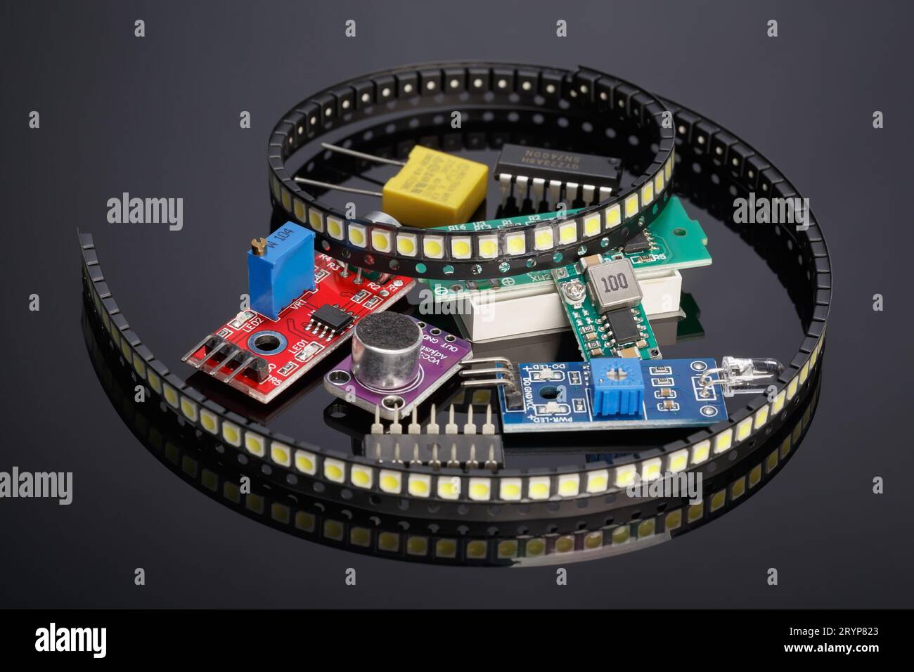 Vari moduli aggiuntivi e componenti radio-elettronici per Arduino su sfondo scuro con riflesso Foto Stock