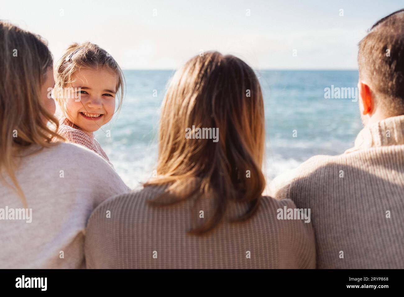 Uomo, donna, adolescente e bambino in riva al mare. Mamma, papa' e adolescente donna in piedi. Foto Stock