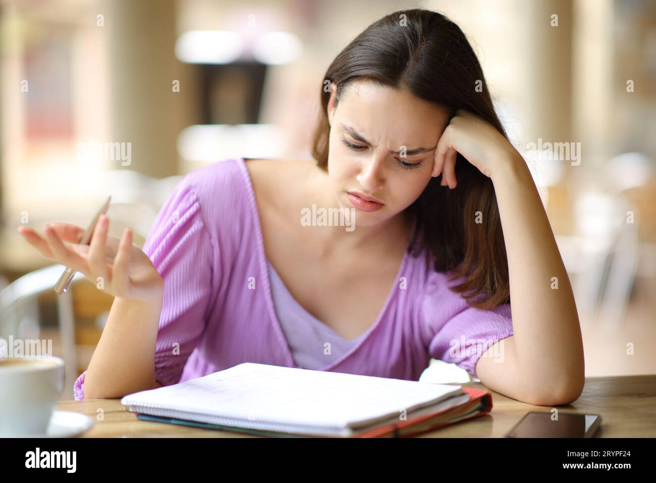 Lezione di verifica degli studenti confusa sul notebook in una terrazza bar Foto Stock