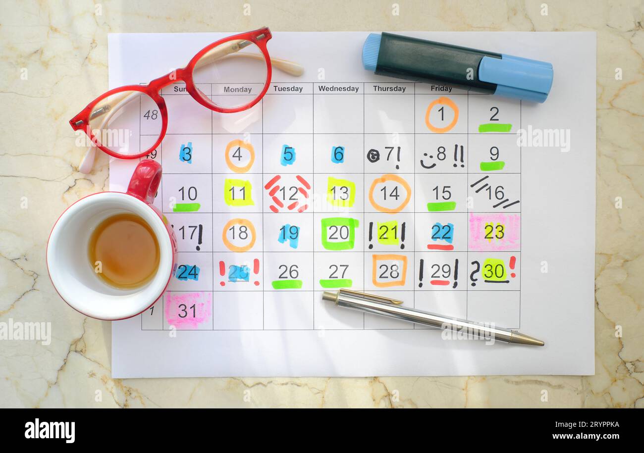 Calendario con appuntamenti di lavoro, penne, tazze da caffè e occhiali, programma mensile. Business concept, battete il cronometro. Foto Stock