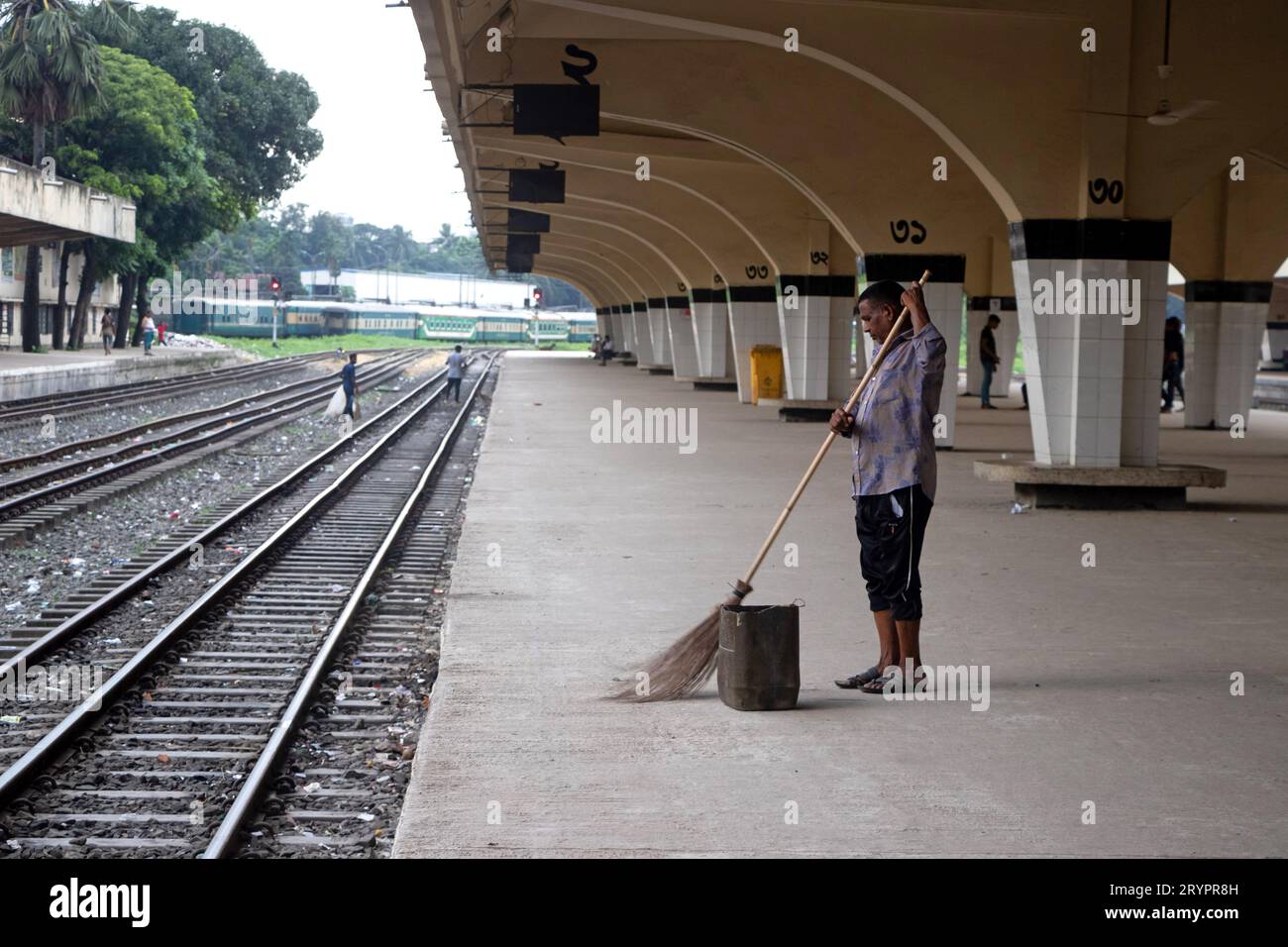 Dhaka, Dhaka, Bangladesh. 2 ottobre 2023. Un addetto alle pulizie spazza il pavimento alla stazione ferroviaria di Kamalapur a Dacca, Bangladesh. I loro instancabili sforzi spesso passano inosservati, eppure svolgono un ruolo vitale nel mantenere la pulizia e l'ordine della stazione. La stazione ferroviaria di Kamalapur è il più grande e vivace snodo ferroviario della nazione. Nota per la sua fusione architettonica di elementi moderni e tradizionali, questa stazione iconica è stata progettata dall'architetto americano Robert Boughey e inaugurata nel 1969. Gestendo quotidianamente un notevole volume di passeggeri e merci, Kamalapur svolge un ruolo fondamentale a Bangla Foto Stock