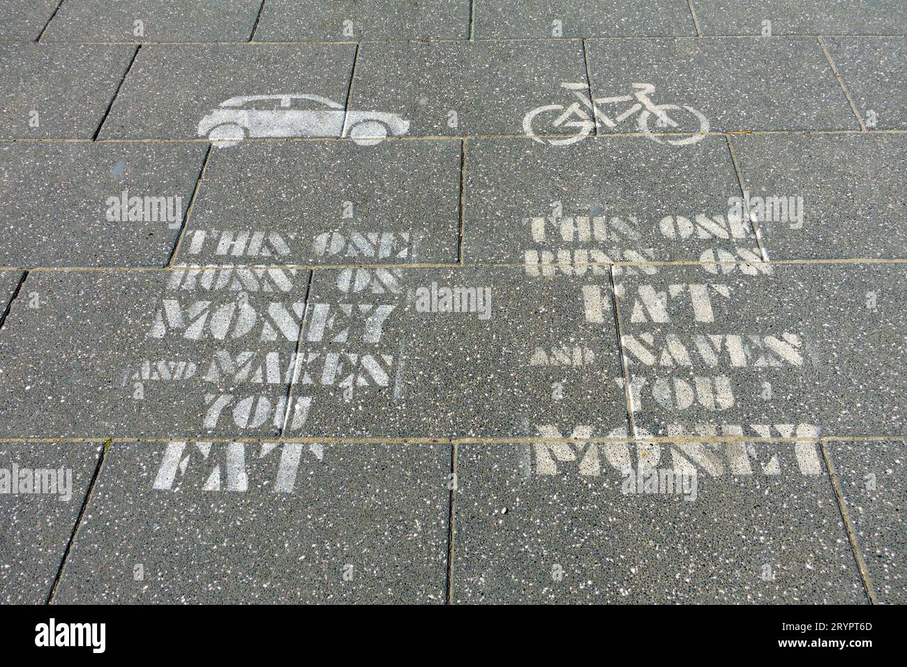 Messaggio stencil salute e ambiente, auto V bicicletta, su una pavimentazione lastra passerella a Bruxelles, belgio Foto Stock