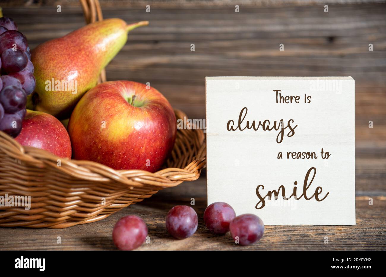 Decorazioni autunnali con pere, mele e uva, sfondo del Ringraziamento, stagione autunnale e testo c'è sempre Un motivo per sorridere Foto Stock