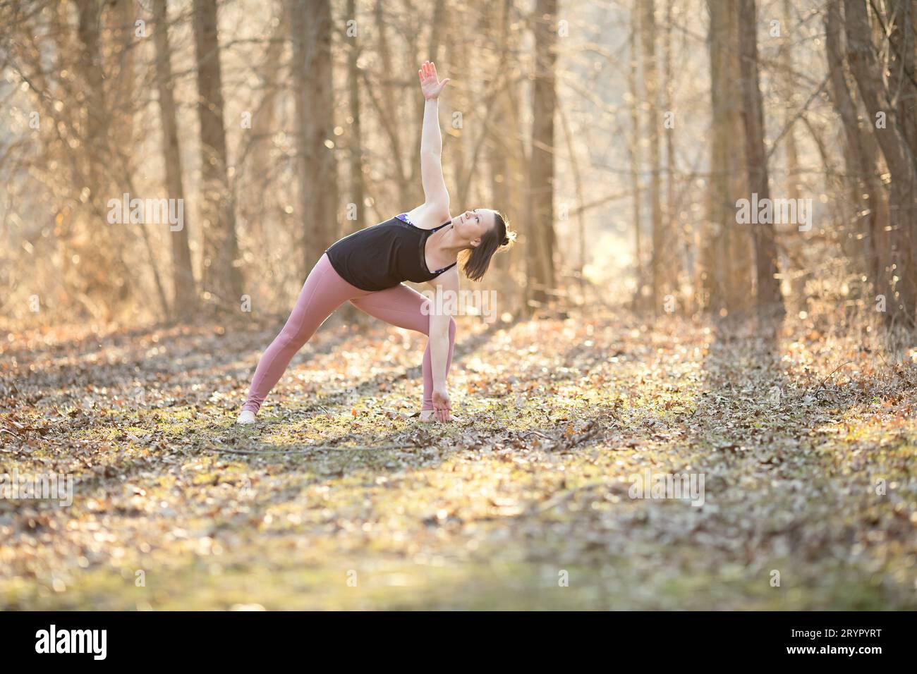 Posa yoga triangolare; donna che pratica yoga all'aperto Foto Stock