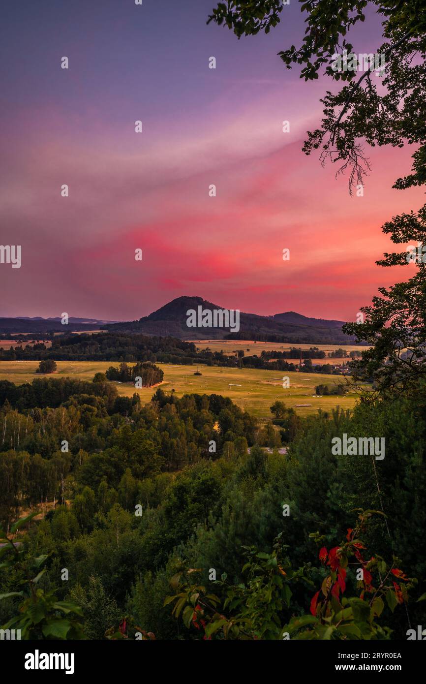 Romantica vista al tramonto nella Boemia settentrionale. Il cielo è pieno di colori e nuvole soffici e rosa. Foto Stock