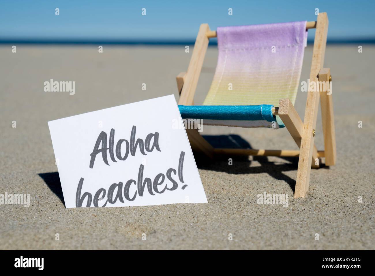 LE SPIAGGE DI ALOHA riportano un biglietto d'auguri di carta sullo sfondo dell'arredamento della sdraio per le vacanze estive. Spiaggia sabbiosa, sole. Holiday Co Foto Stock