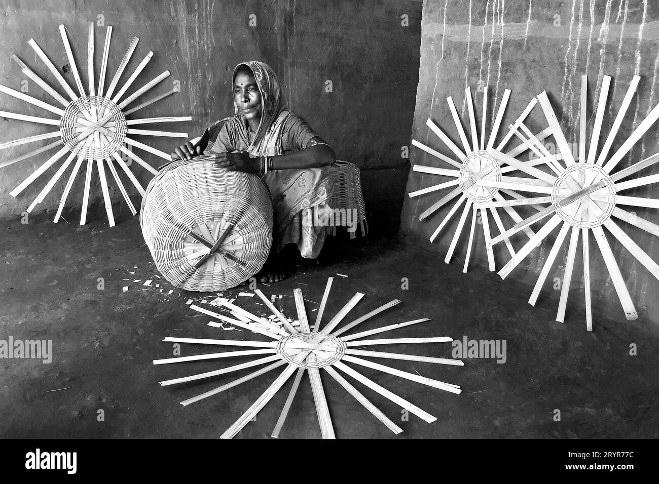 La donna che fa un cesto di bambù nel remoto villaggio del Bengala Occidentale in India. Foto Stock