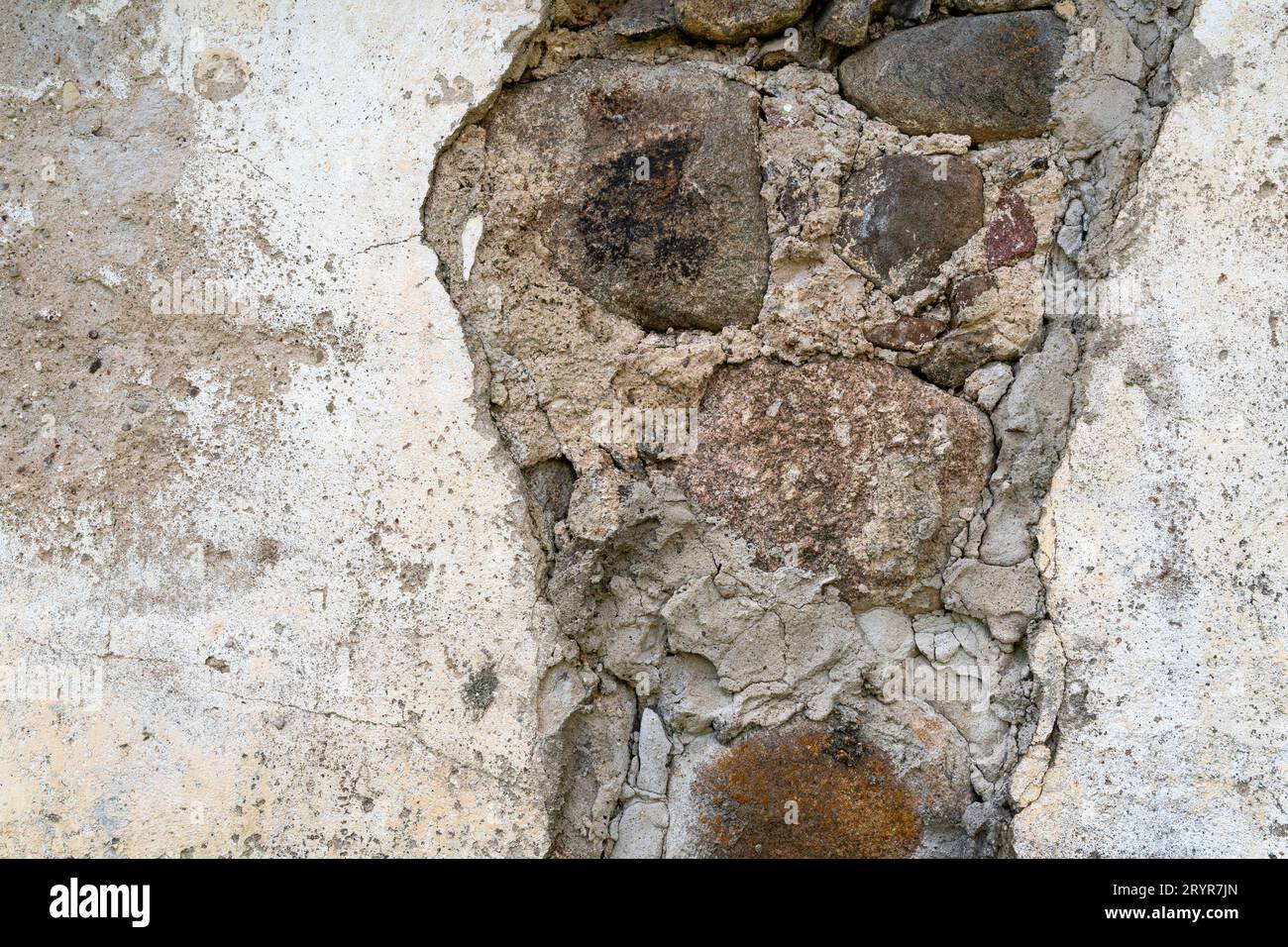 Sfondo di un antico muro di pietra con l'intonaco caduto Foto Stock