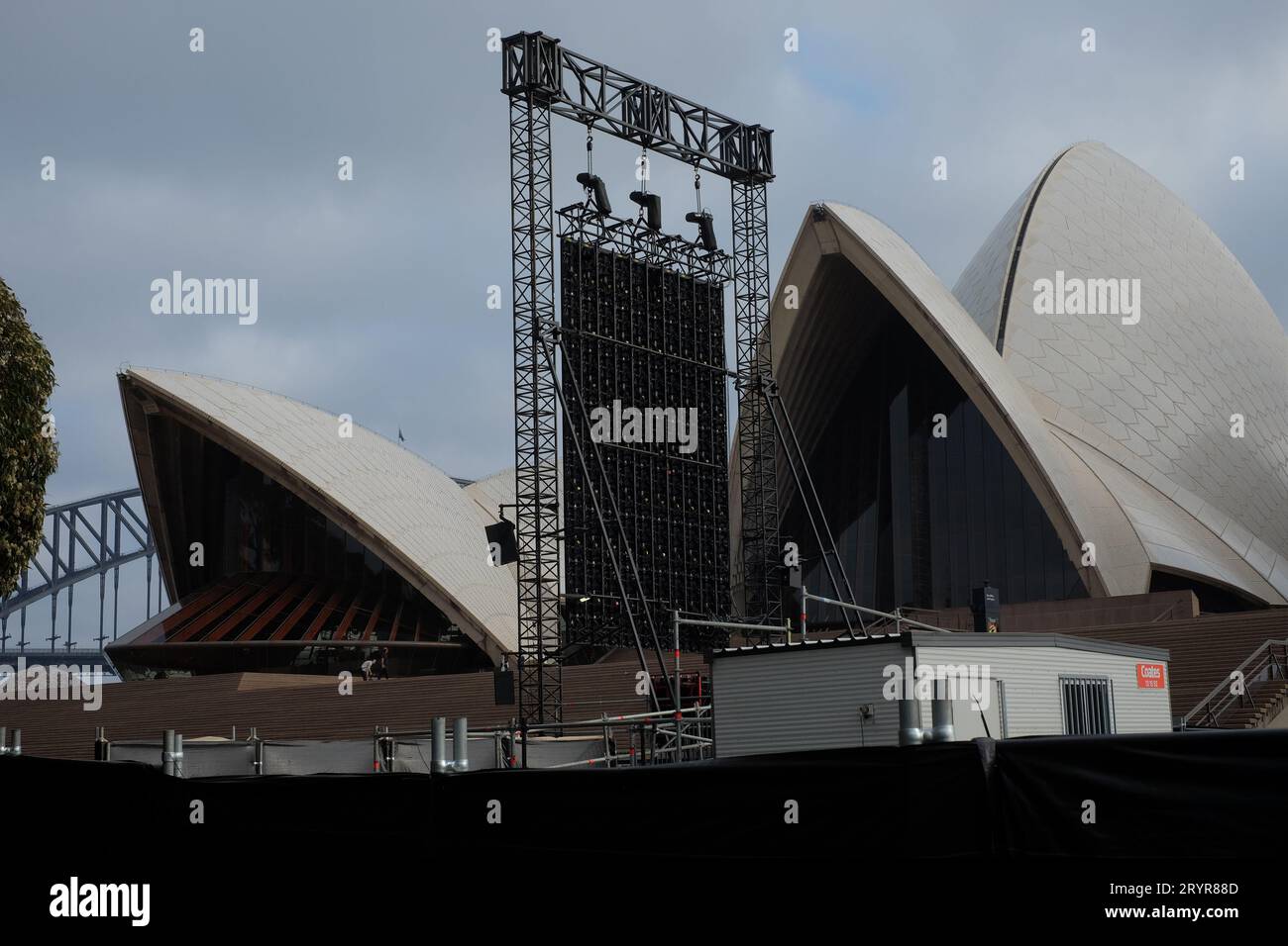 Per uno spettacolo all'aperto, il piazzale della Sydney Opera House con recinzione a barriera con telo in poliestere nero, impianto di illuminazione, conchiglie e scalini monumentali Foto Stock