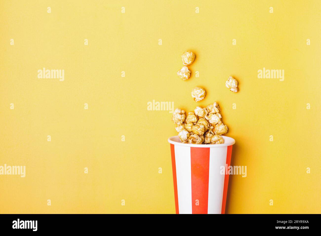 Pop corn caramello dolce in tazza bianca rossa a strisce di carta Foto Stock