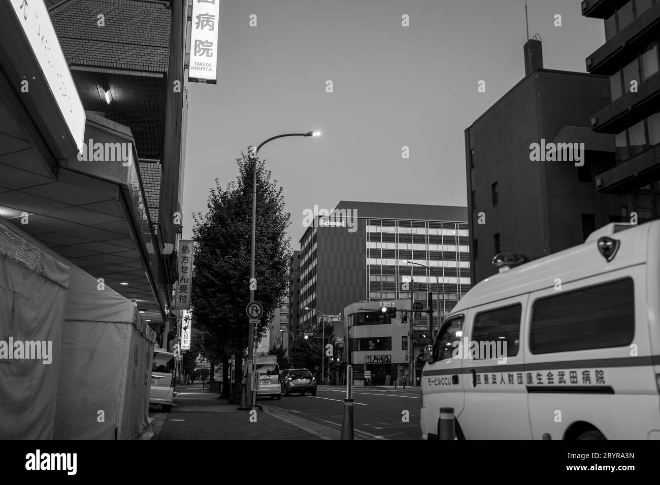 Uno scatto in scala di grigi di una strada trafficata della città con autobus e automobili Foto Stock