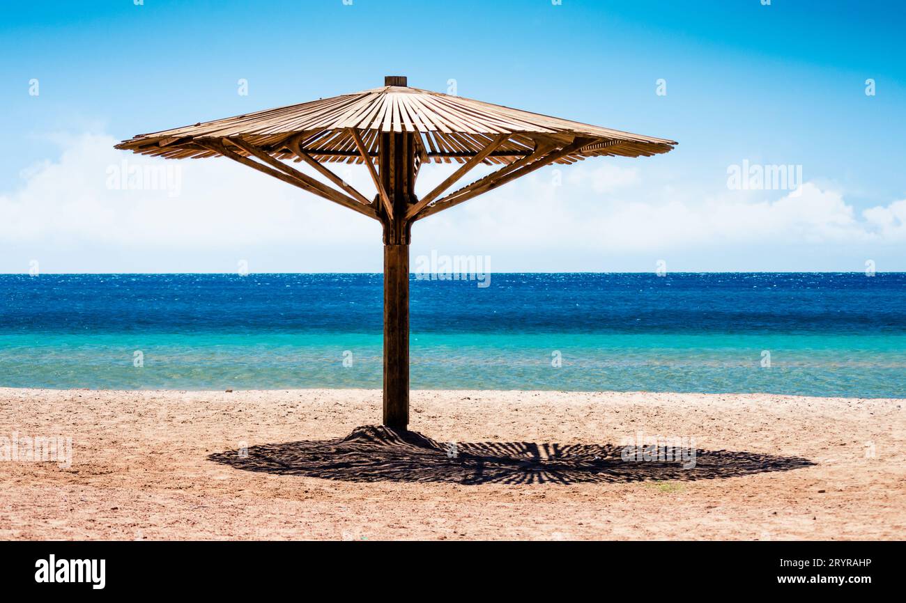 Ombrellone in legno sulla riva senza la gente del Mar Rosso in Egitto Foto Stock