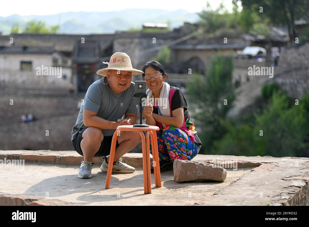 (231002) -- TAIYUAN, 2 ottobre 2023 (Xinhua) -- Villager Chen Yuxiang (R) e suo figlio li Yanjun do Livestream nell'antica città Qikou della contea di Linxian, nella provincia dello Shanxi della Cina settentrionale, 2 agosto 2023. Chen ha iniziato a introdurre le prelibatezze locali e a mostrare il paesaggio dell'antica città di Qikou via Livestream nel 2021. Presto ha raccolto più di 200.000 follower. Qikou, un'antica città fluviale lungo il fiume giallo, era un importante traghetto commerciale nella storia. Tuttavia, con lo sviluppo del trasporto terrestre, l'antica città di Qikou diminuì in termini di volume commerciale, lasciando molti dei suoi storici Foto Stock