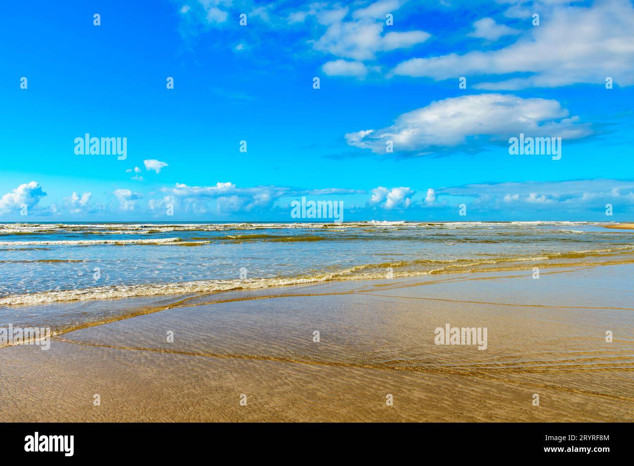 Spiaggia tranquilla e deserta con piccole onde e acque cristalline Foto Stock