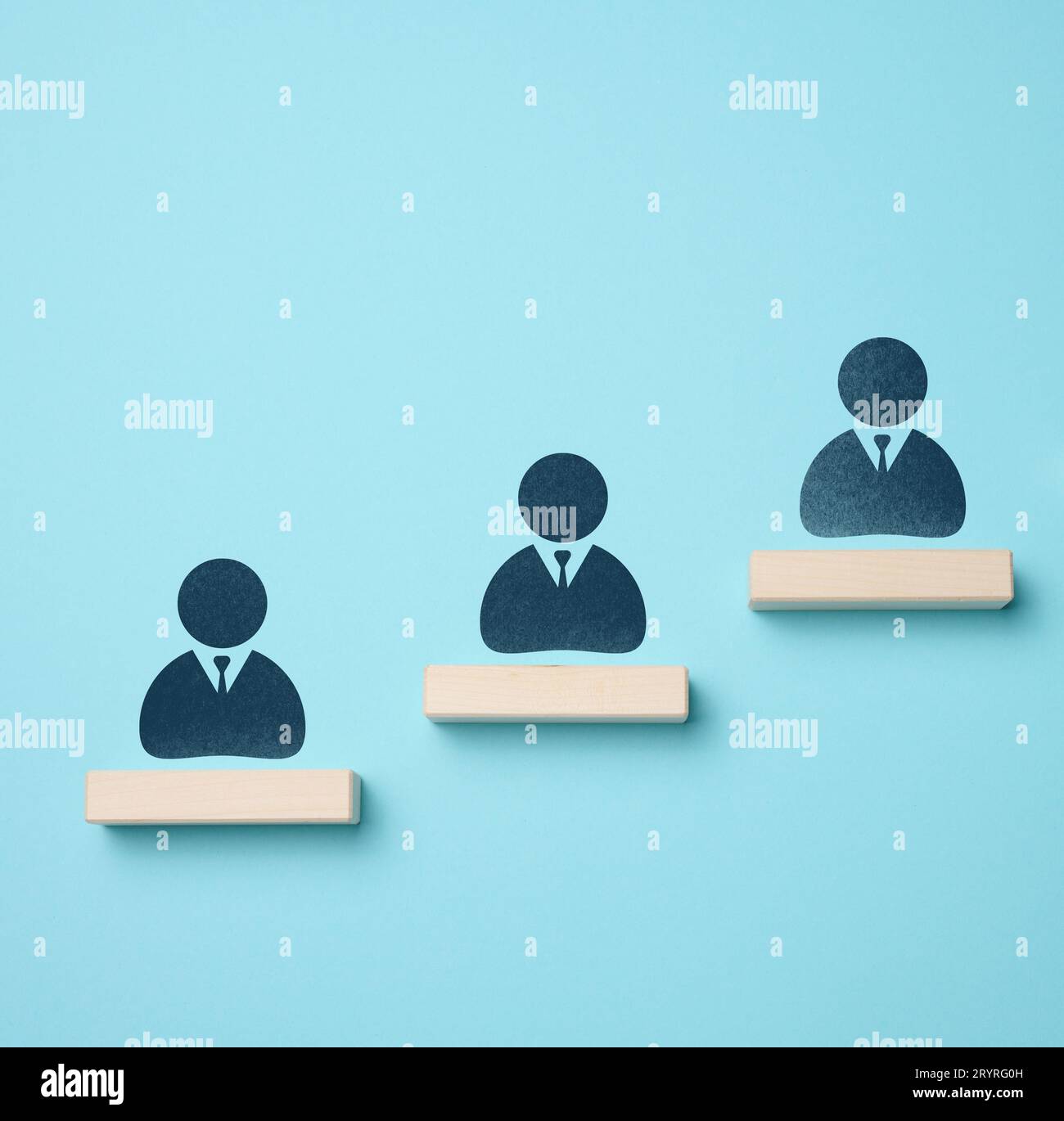 Il concetto di leadership nel business, la valutazione dei dipendenti di talento. Barre di legno e icone del personale su sfondo blu Foto Stock