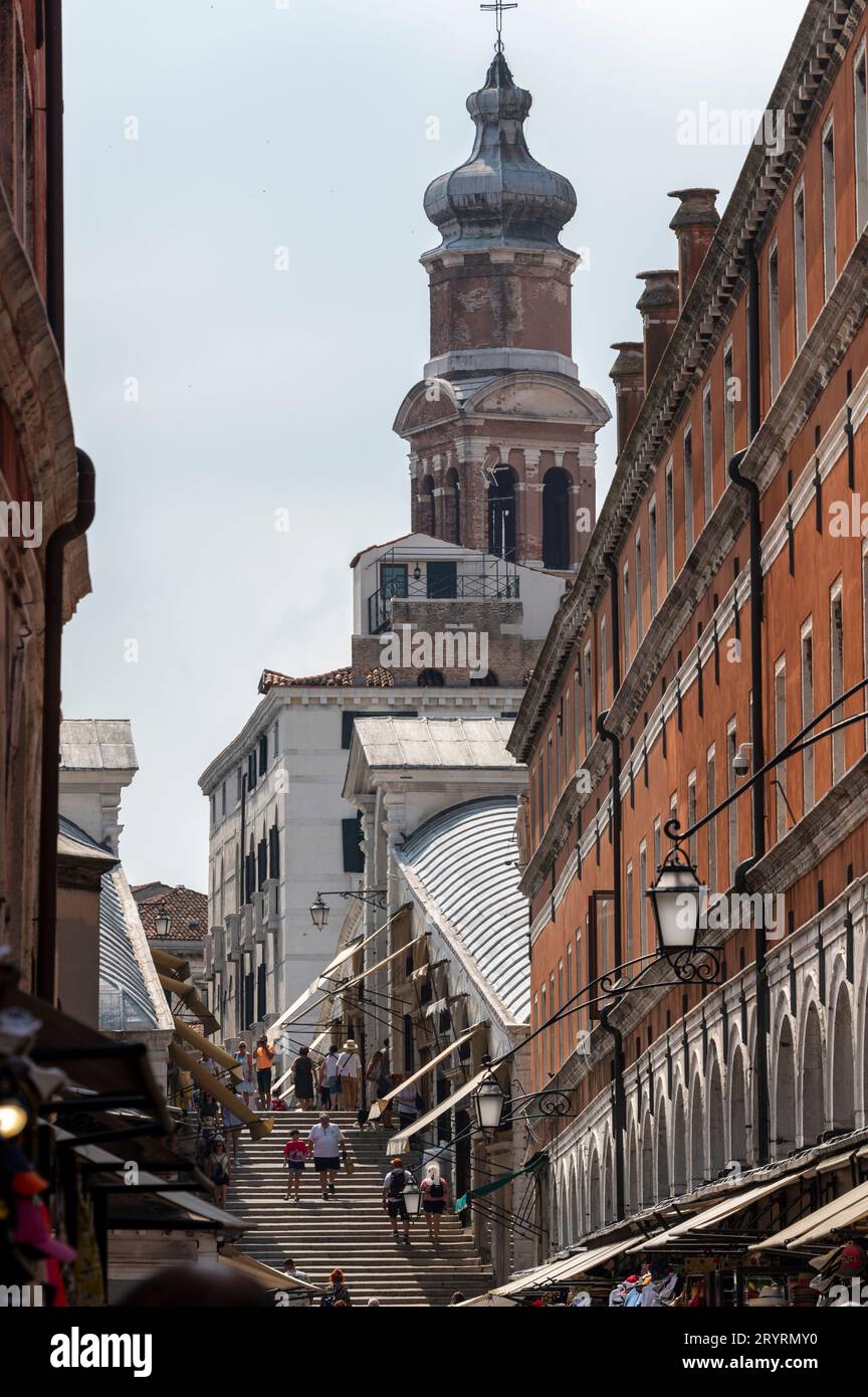 Turisti su una rampa di scale con piccoli negozi su entrambi i lati del Ponte di Rialto a Venezia, nella regione Veneto del nord Italia. Foto Stock