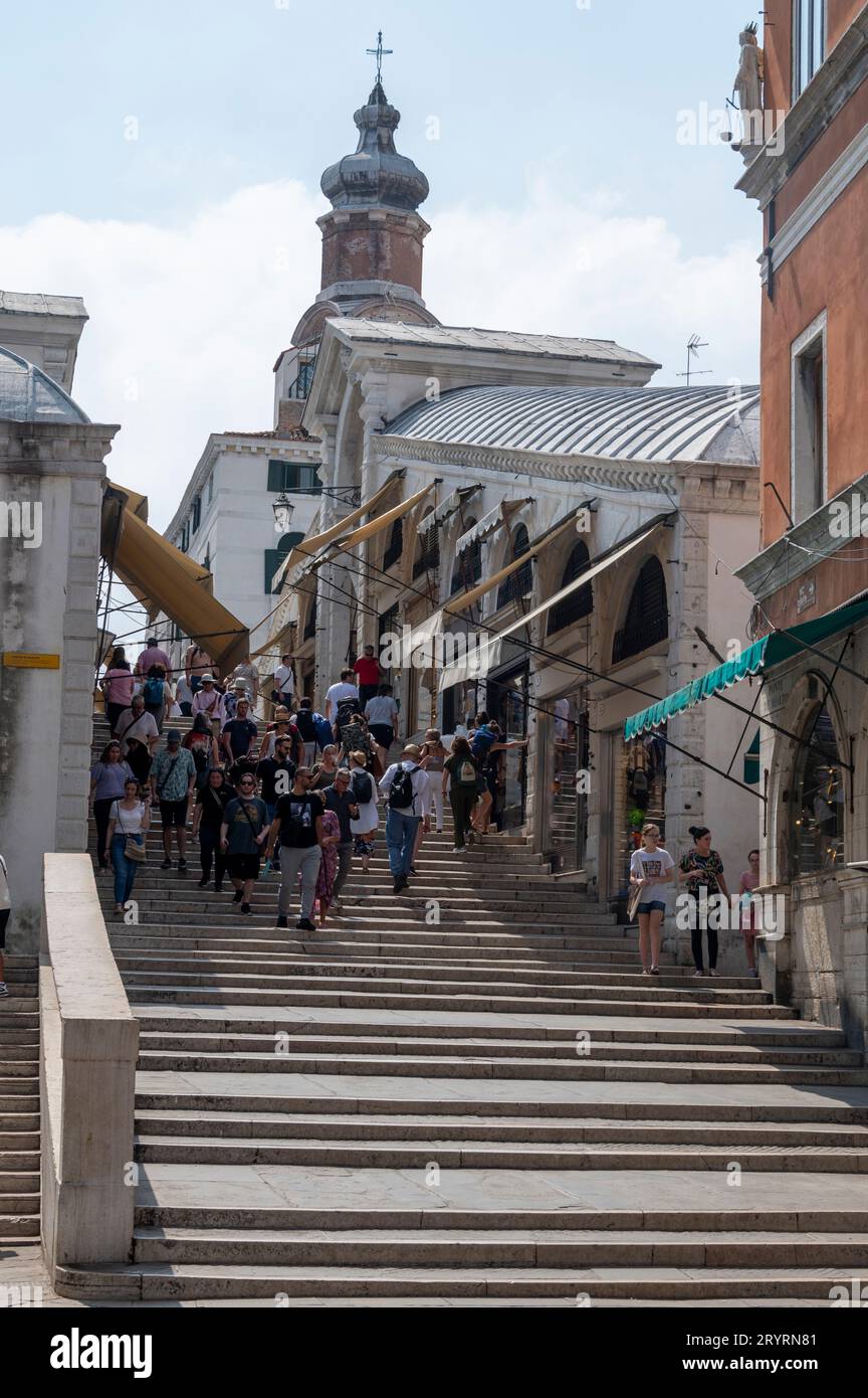 Turisti su una rampa di scale con piccoli negozi su entrambi i lati del Ponte di Rialto a Venezia, nella regione Veneto del nord Italia. Foto Stock