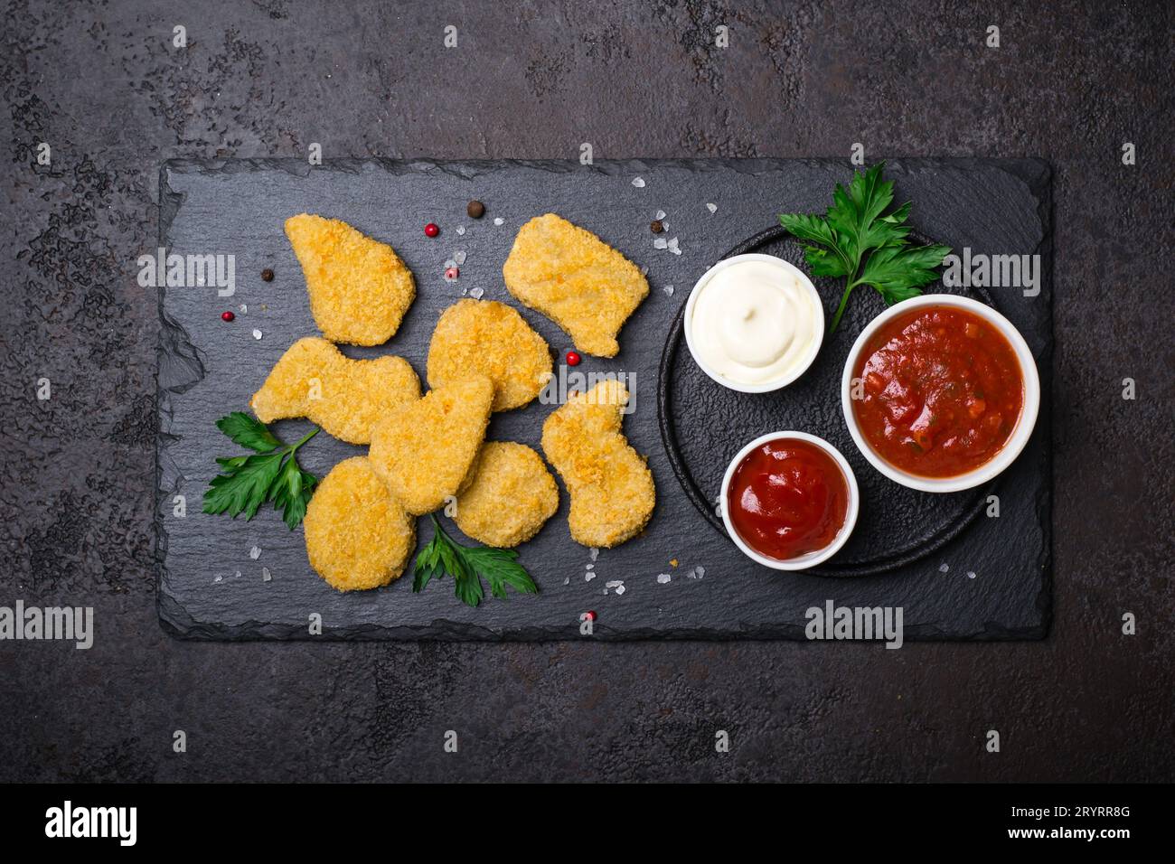 Pepite di pollo croccanti fritte con salse popolari Foto Stock