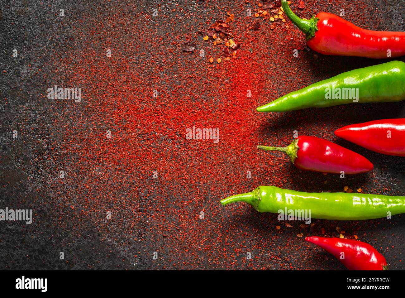 Pepe piccante rosso e verde e pepe macinato secco su sfondo scuro Foto Stock