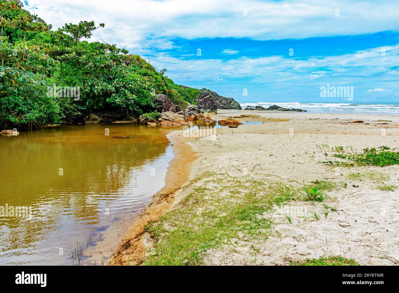 Il fiume va verso il mare sulla spiaggia Foto Stock