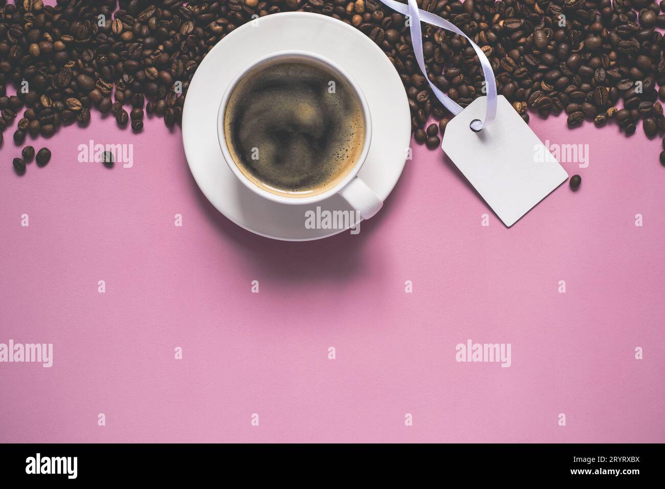 Sfondo vintage rosa con tazza di caffè, chicchi di caffè e cartellino Foto Stock