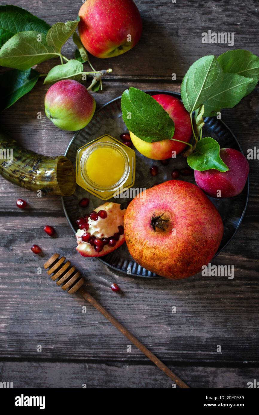 Immagine religiosa del concetto di Rosh hashanah (festività ebraica di Capodanno). Simboli tradizionali: Miele, mele e melograno su un buio Foto Stock