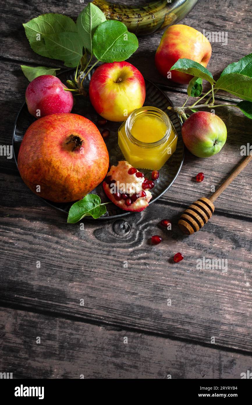 Immagine religiosa del concetto di Rosh hashanah (festività ebraica di Capodanno). Simboli tradizionali: Miele, mele e melograno su un buio Foto Stock