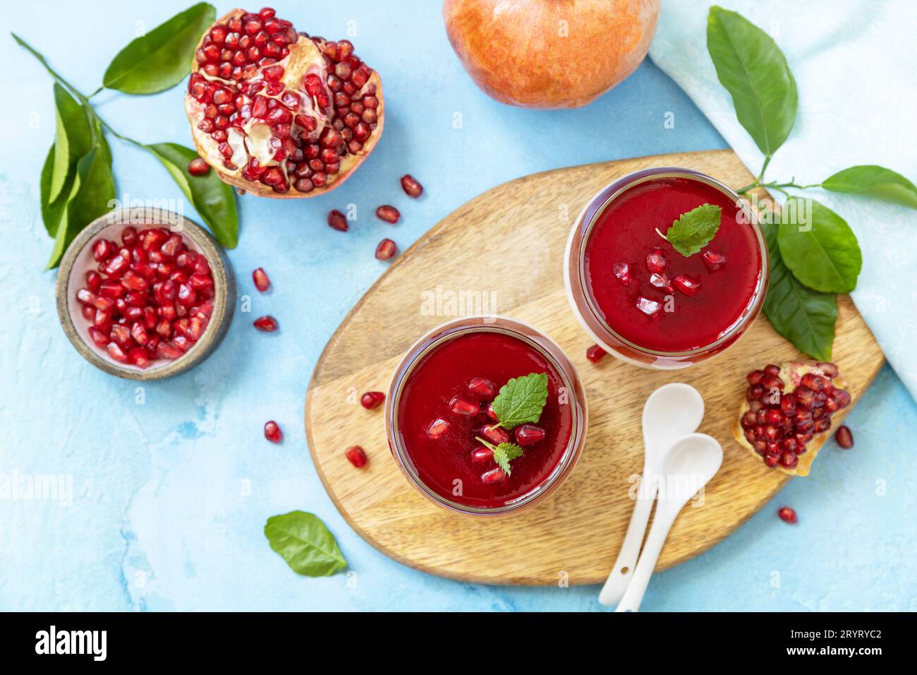 Panna cotta invernale con gelatina di melograno e menta, dessert italiano, cucina fatta in casa. Vista dall'alto, disposizione piatta. Foto Stock