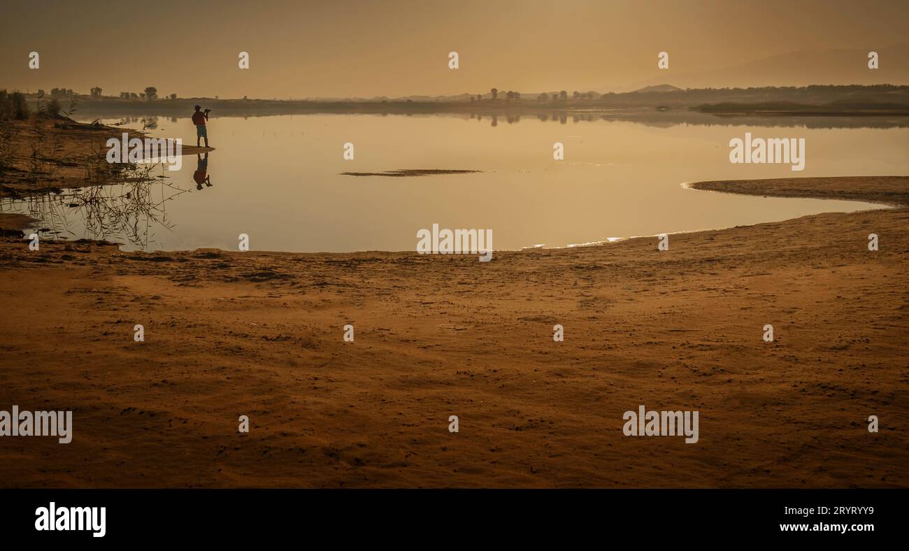 Un uomo vicino al lago ad Alain, Emirati Arabi Uniti Foto Stock