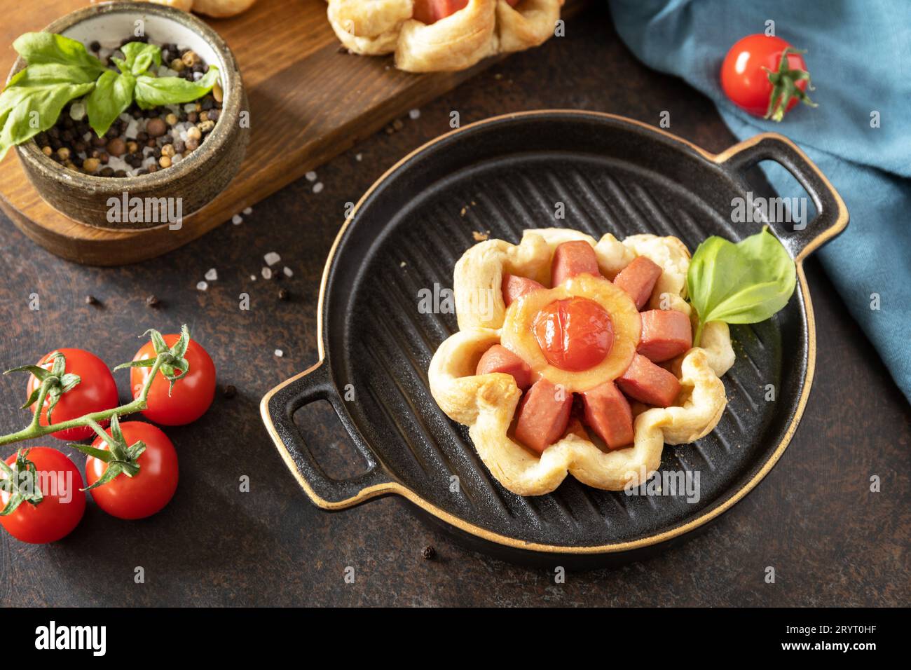 Mini pizza, colazione. Pizza in pasta sfoglia con formaggio e pomodori su un tavolo di pietra. Foto Stock