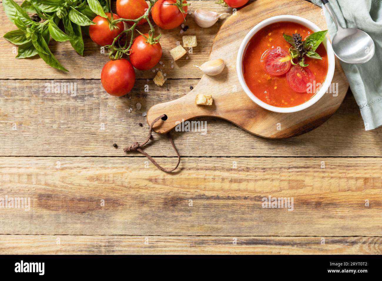 Purea di pomodori per zuppa vegana. Dieta sana a basso contenuto di carboidrati. Ciotola di zuppa di pomodoro con basilico e crostini su un tavolo rustico. Visualizza da Foto Stock