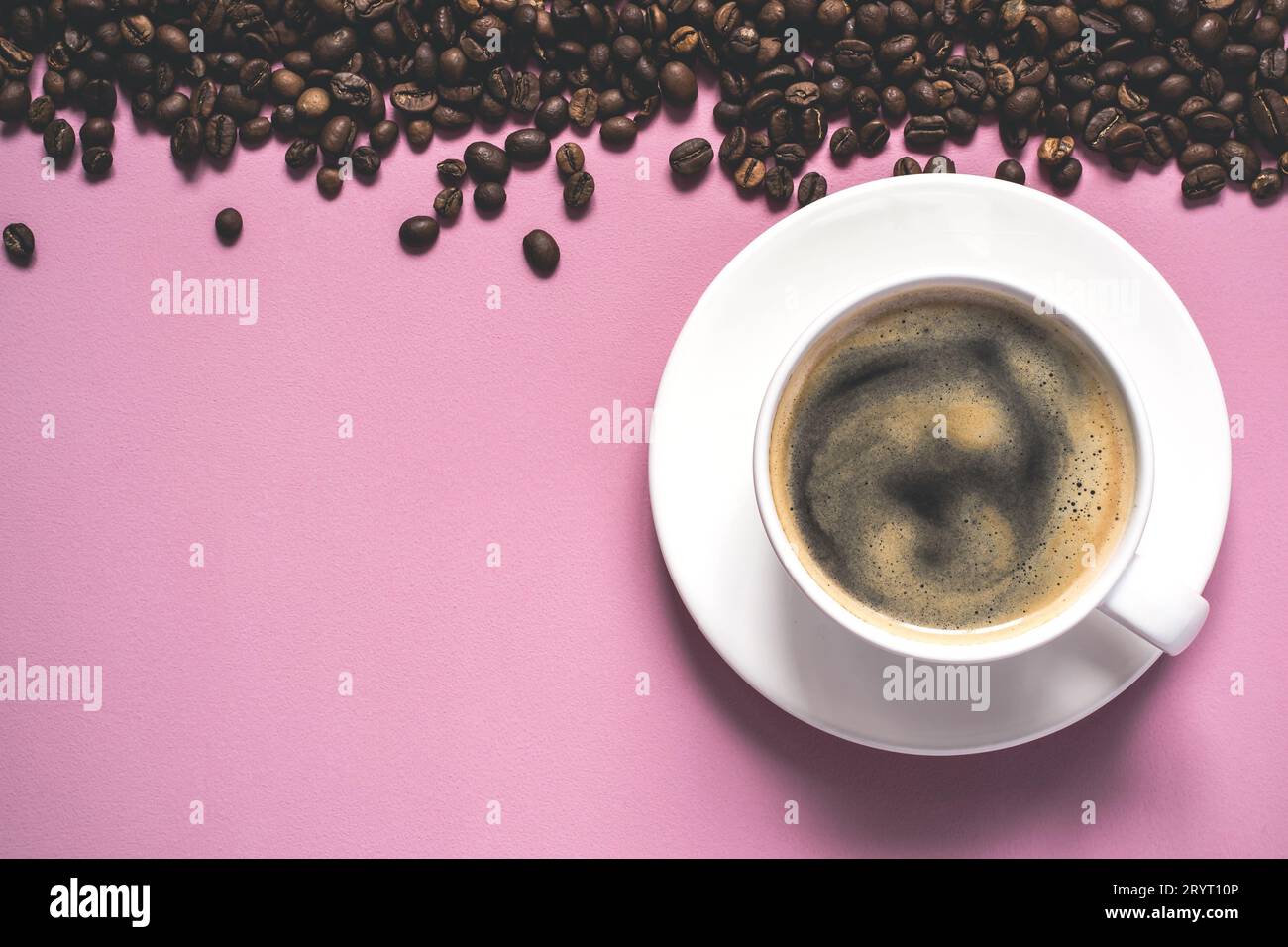 Tazza di caffè con schiuma e chicchi su sfondo rosa Foto Stock