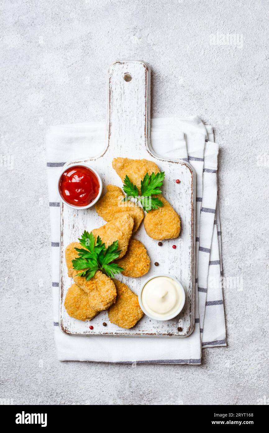 Pepite di pollo croccanti fritte con salse popolari Foto Stock