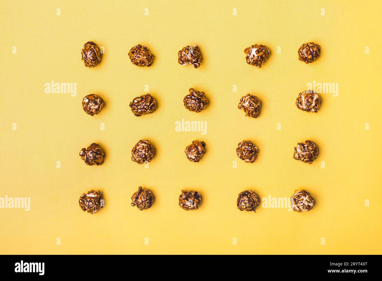 Schema alimentare di popcorn al cioccolato su sfondo giallo Foto Stock