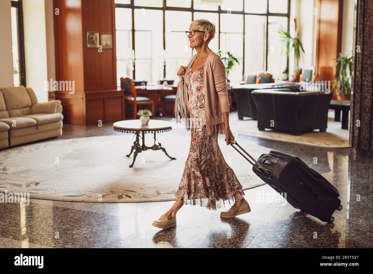 Una donna matura viene in hotel alla reception. Foto Stock