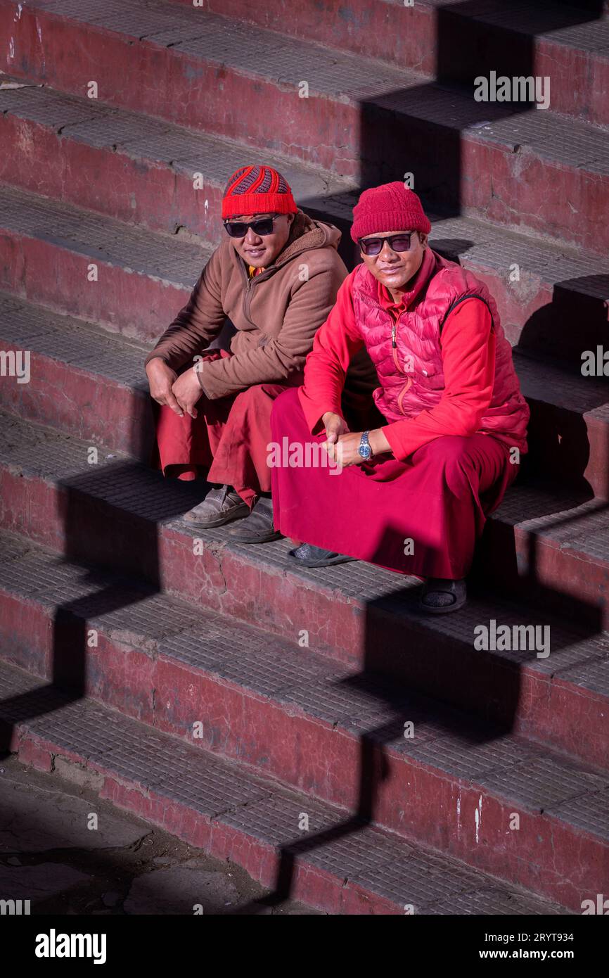 Due monaci seduti sulle scale per il monastero di Korzok, Korzok, Ladakh, India Foto Stock